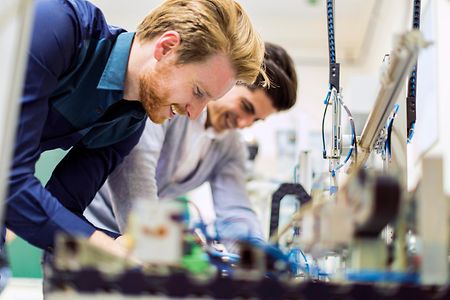 Zwei junge Männer arbeiten mit elektronischen Komponenten.
