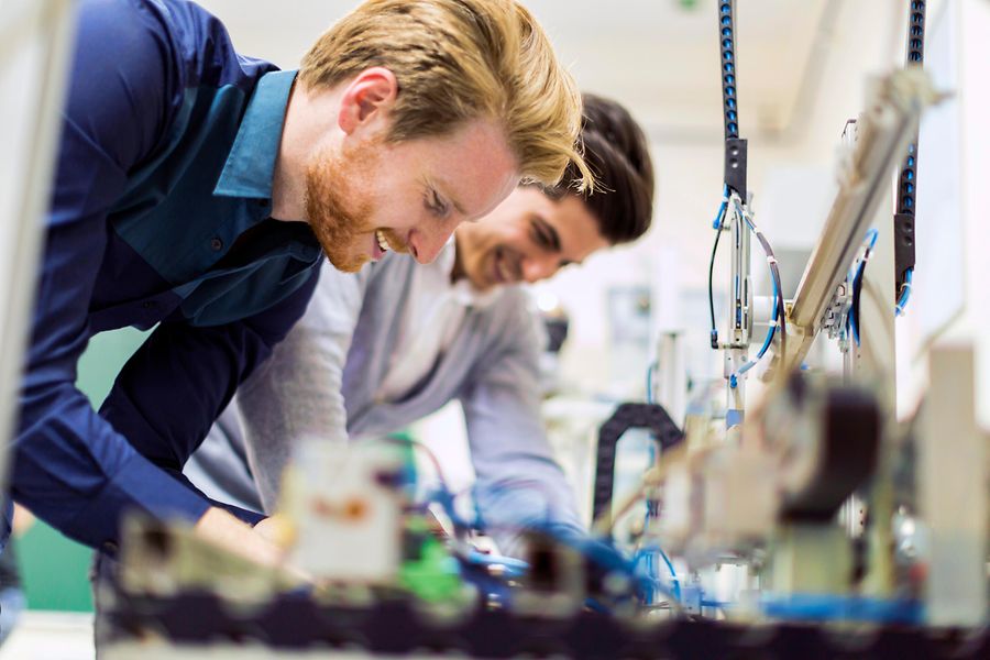 Zwei junge Männer arbeiten mit elektronischen Komponenten.